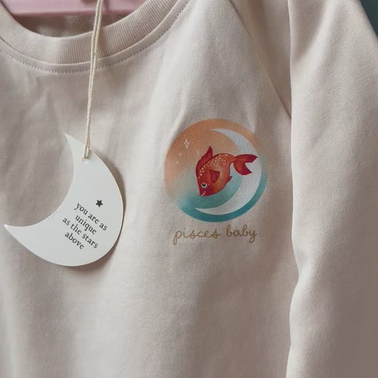 pisces toddler crewneck paired with the pisces zodiac baby book