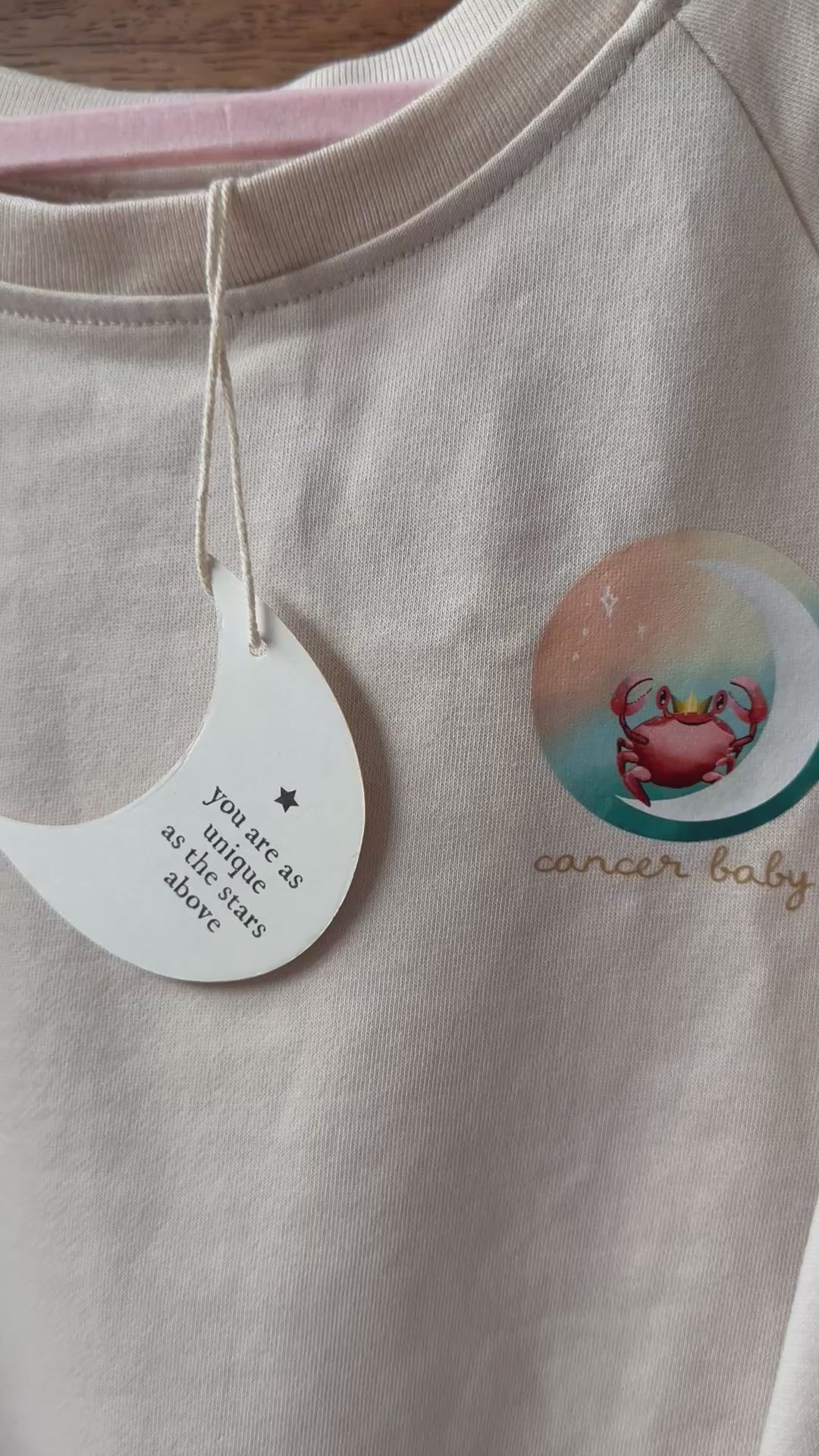 cancer baby crewneck for children featuring a crab and its matching zodiac baby book for the ultimate new baby gift set