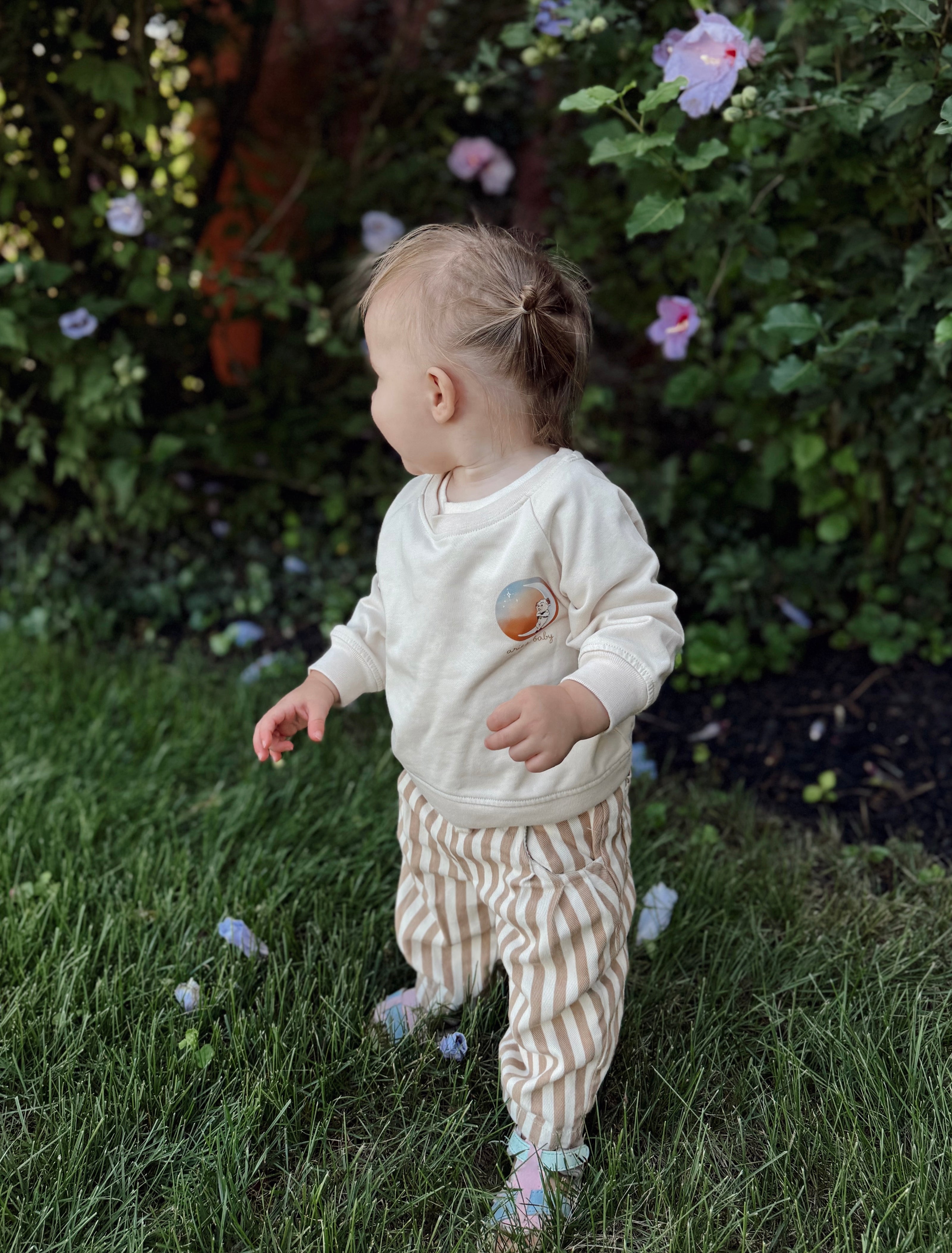 toddler wearing an aries baby zodiac sign cotton blend crewneck with the aries symbol on the sleeve