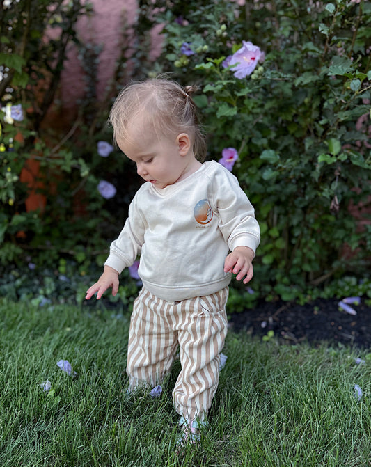 toddler wearing an aries baby zodiac sign cotton blend crewneck with the aries symbol on the sleeve