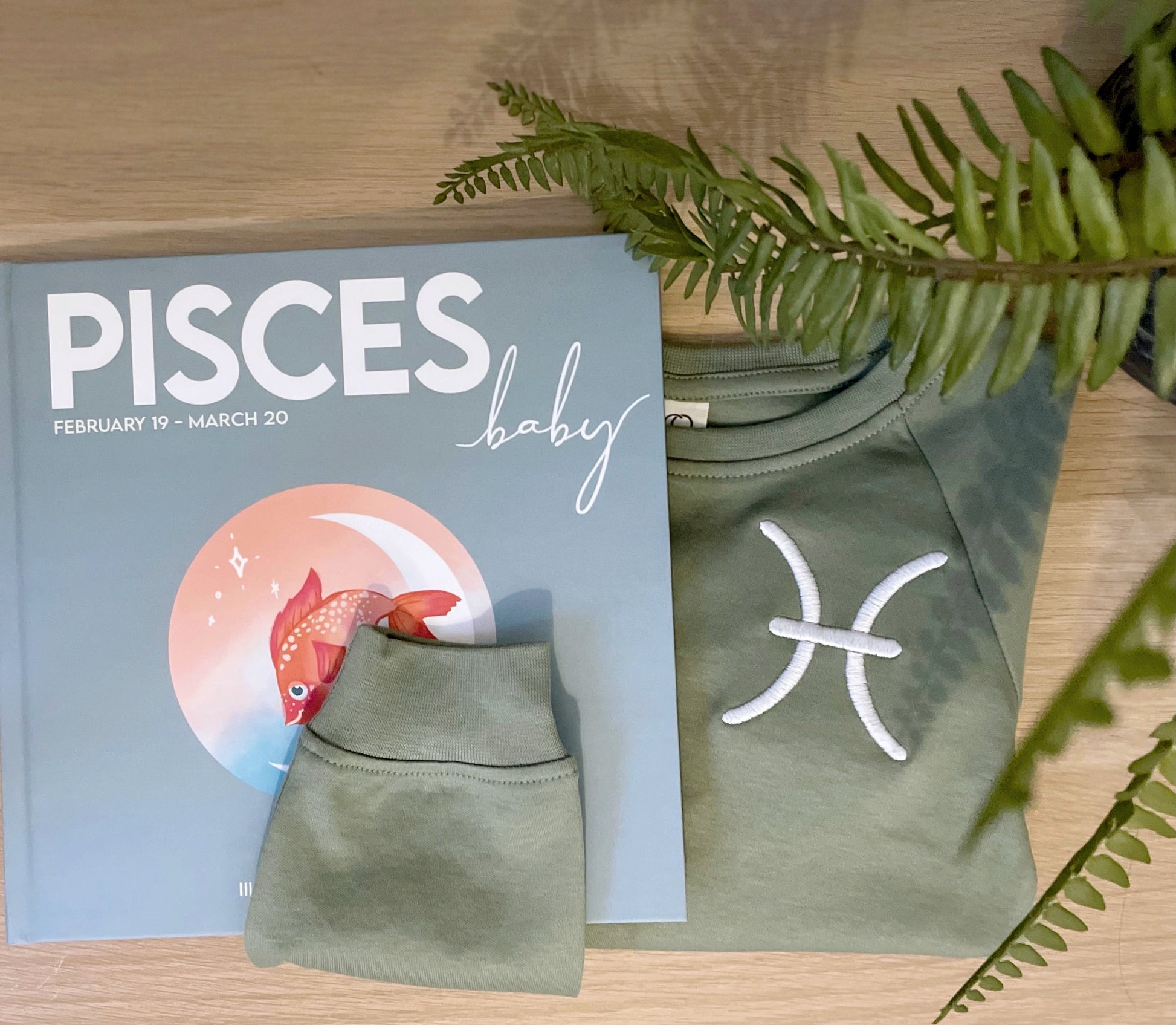 pisces zodiac baby book and its matching zodiac baby sweatshirt.